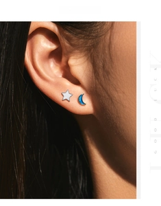 Close-up of asymmetric s925 silver star and moon stud earrings on model ear