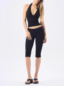 Detailed view of black V-neck halter top and slim leggings with high-waist design