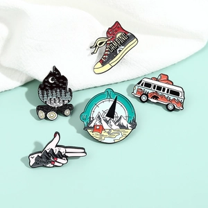 Outdoor adventure enamel pins set with camping bus, hiking boots, and compass