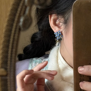 Blue flower tassel earrings with metal leaves and water drop pendant on a model