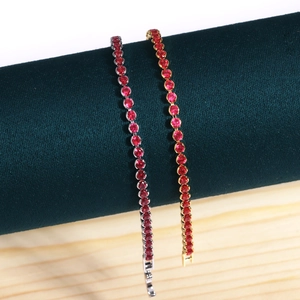 Detail view of red crystal tennis bracelets in gold and silver finish on velvet roll