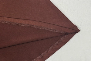 Detail view of the fine overlock stitching on high-quality brown fabric edge