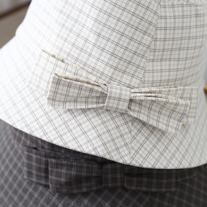 Gros plan d'un chapeau cloche à carreaux avec un nœud décoratif et un tissu aéré
