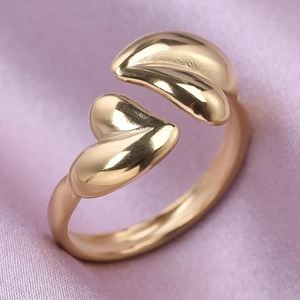 Macro shot of double heart-shaped gold open ring on silk fabric with polished finish