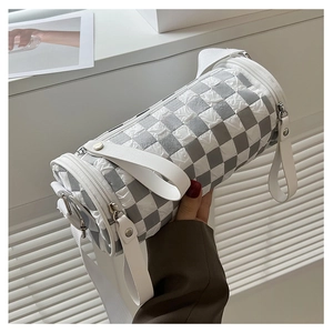 Macro detail of cylinder crossbody bag with grey checkerboard pleated fabric texture