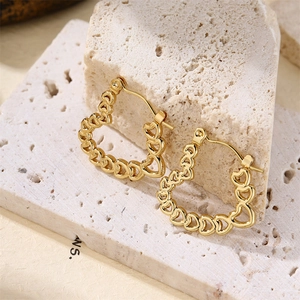 Détail macro de boucles d'oreilles cœur creuses plaquées or 18 carats sur pierre naturelle