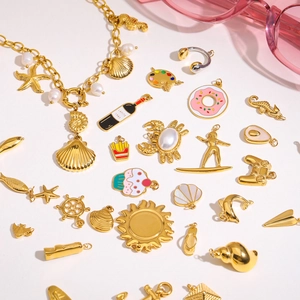 Detailed macro shot of assorted gold marine charms including starfish and enamel shells