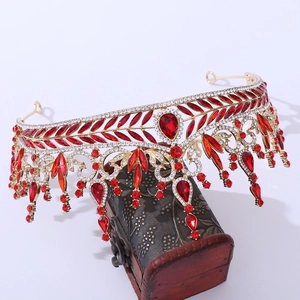 Macro view of luxurious gold crown with red crystals and leaf motifs on a vintage box