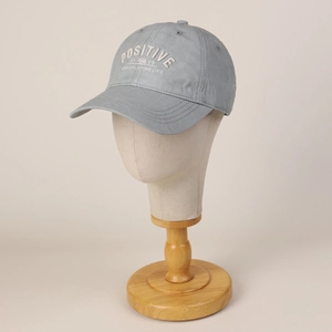 Détail de la broderie Positive sur la casquette de baseball en coton bleu clair