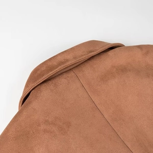 Detailed close-up of brown faux suede lapel and shoulder seams on double-breasted coat