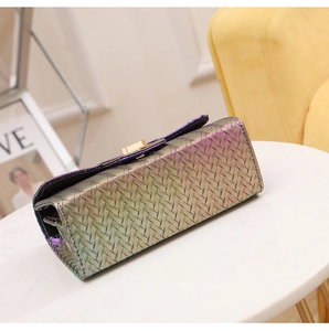 Detail of gradient woven crossbody bag with metallic gold buckle on a white surface