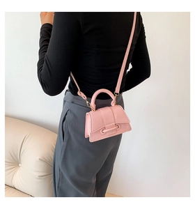 Pink lychee grain leather mini crossbody bag shown on a model for size perspective