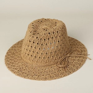 Detailed close-up of hollow-out woven straw hat texture with a decorative bow detail