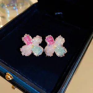 Gradient floral crystal stud earrings in rose gold finish on a luxury velvet display