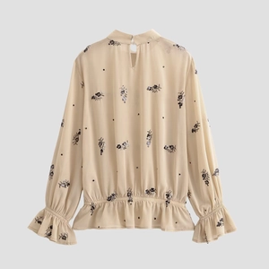 Blouse beige en mousseline à manches longues avec broderie florale et col montant boutonné