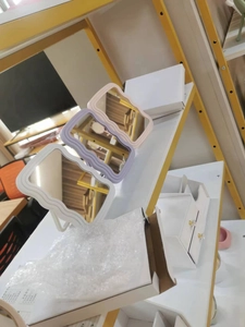 Vue détaillée de miroirs de maquillage ondulés en blanc, violet et rose sur étagère