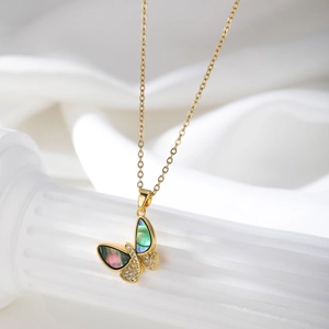Close-up of golden butterfly necklace with iridescent shell inlay and sparkling zircons