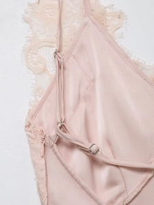 Détail de caraco en satin rose avec bordure en dentelle et bretelles réglables