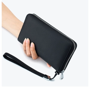 Close-up of black litchi grain leather long wallet with silver zipper and wrist strap