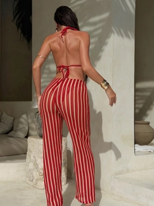 Vue arrière femme avec haut bikini licou rouge et pantalon large en maille à rayures verticales