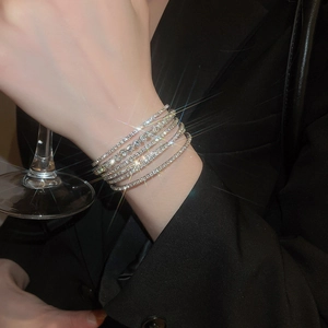 Detail shot of multi-layered rhinestone tennis bracelets worn for a formal evening look