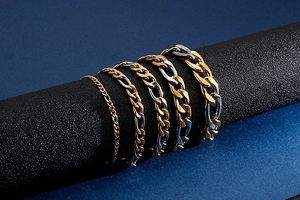 Detail showing five different widths of gold and silver bicolor Figaro chain bracelets