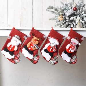 Set of four red linen Christmas stockings with 3D Santa and Reindeer appliques on fireplace