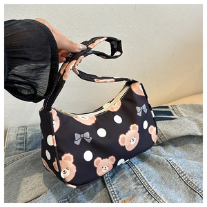 Close-up of cute cartoon bear and bow patterns on black nylon underarm shoulder bag