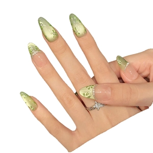 Green cat-eye press-on nails with floral pattern and pearl accents for a fresh spring look