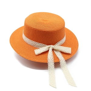 Women's orange straw sun hat with white lace bow detail shown in 45-degree angle view