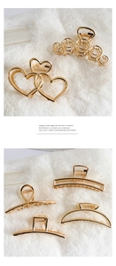 Detail view of golden metal hair claws in heart and geometric shapes on white fur