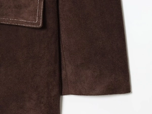 Nahaufnahme des hochwertigen dunkelbraunen Wildleder-Stoffs mit präzisen Nähten am Blazer