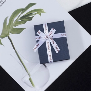 Detail of dark blue jewelry gift box with a white ribbon featuring Crystal Jewelry text