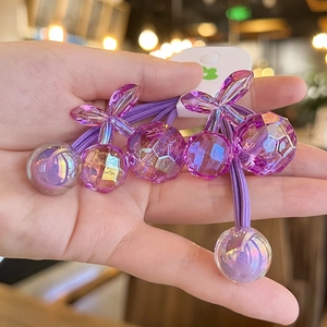 Detail of purple cherry hair ties with faceted beads and bow charms for ponytails