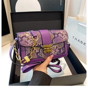 Close-up of purple snakeskin flap bag featuring a vintage gold clasp and chain detail