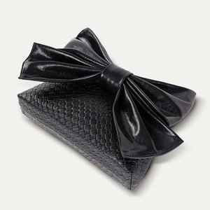 Detail showing black woven texture leather and large bow design on this stylish evening bag