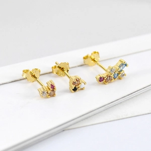 Detailed macro view of S925 silver stud earrings with colorful zircon stones in gold finish