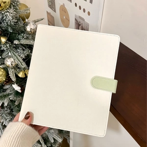 Detail of white PU leather binder cover with shimmer finish and light green buckle