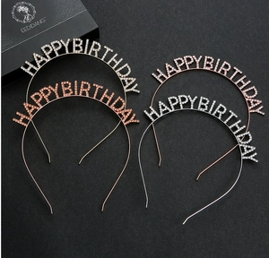 Detail of silver and rose gold rhinestone Happy Birthday headbands on dark background