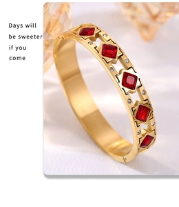 Detalle de una pulsera chapada en oro con circonitas rojas cuadradas y diseño filigrana