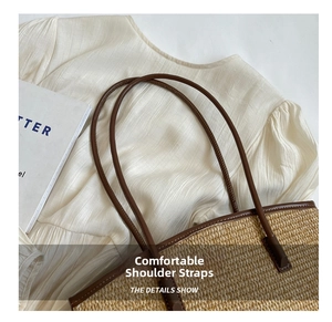 Detailed close-up of woven straw tote texture with premium brown leather shoulder straps