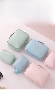 Trois trousses de maquillage imperméables aux tons pastels avec poignées et zips