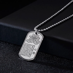 Detailed macro view of silver lotus military tag necklace with engraved Heart Sutra text