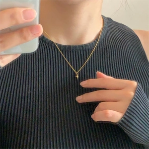 Golden star pendant necklace on dainty O-chain shown on a model in a mirror selfie