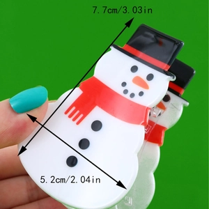Cute snowman Christmas hair claw clip with dimensions 7.7cm x 5.2cm on green background