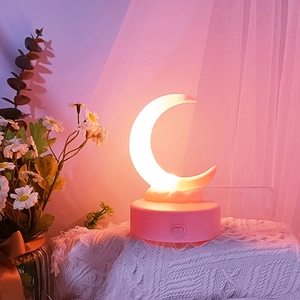 Macro shot of warm crescent moon light with a pink base and heart-shaped power button