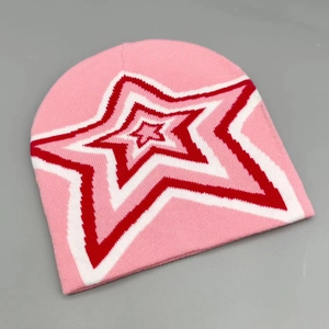 Detail of pink knitted beanie featuring a red and white layered star pattern embroidery