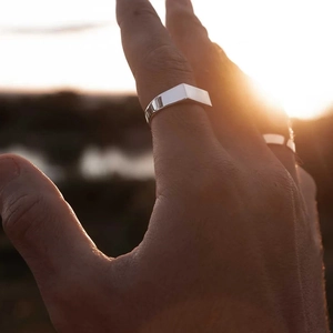 Polished silver stainless steel square ring for men worn during sunset outdoors