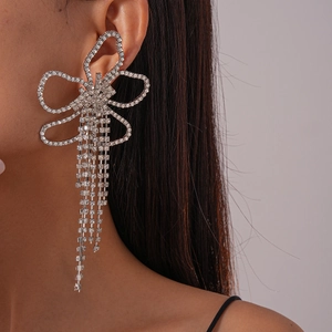 Detailed close-up of a silver butterfly earring with long sparkling rhinestone tassels