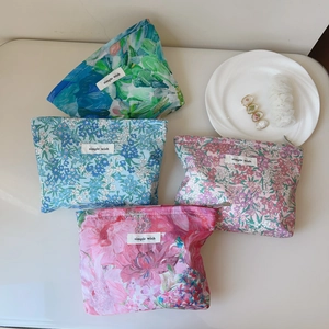 Detailed view of four colorful floral canvas cosmetic bags with simple wish labels